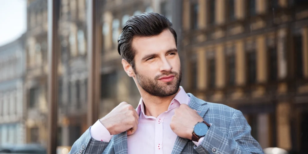 Confident man in a suit adjusting his collar, demonstrating the professional look achievable with Hair Systems.